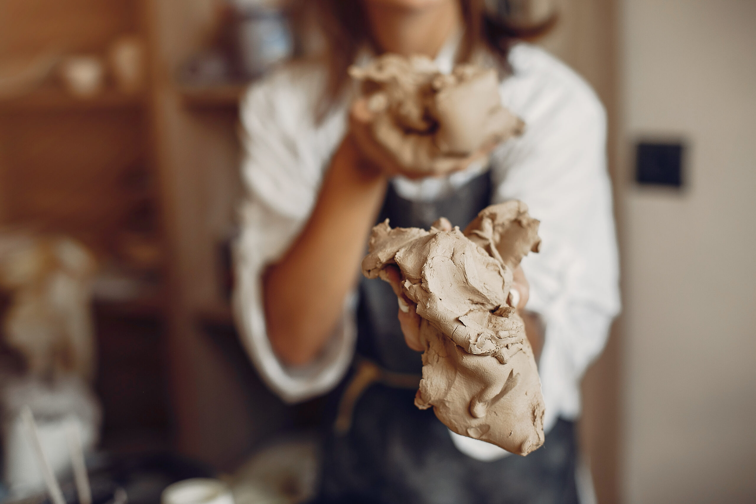A young woman makes dishes in a pottery